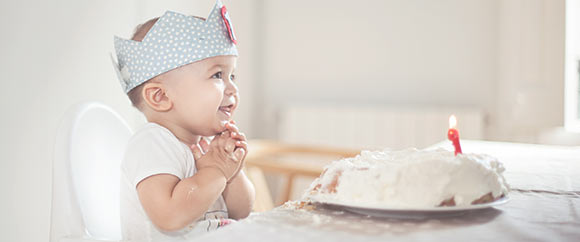 Little boy sitting in front of birthday cake