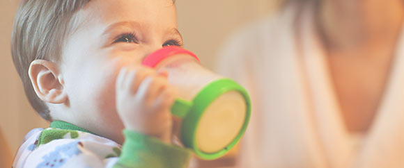 Baby drinking out of beaker